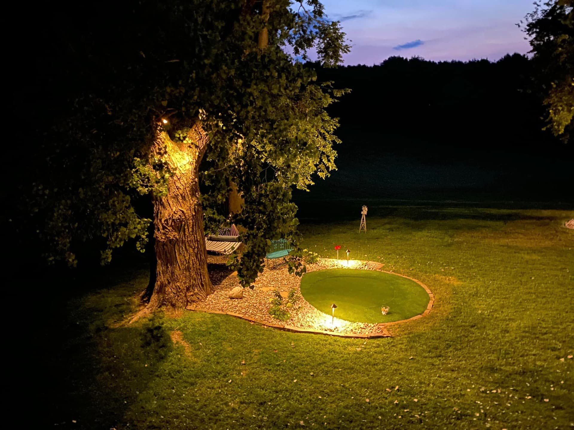 Custom outdoor lighting design with uplighting and putting green in Kansas City